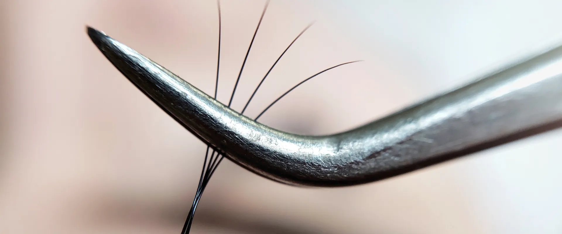 Lash artist using j-type curved tweezers