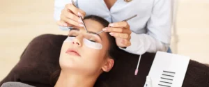Lash artist applying extensions to a client in a professional salon